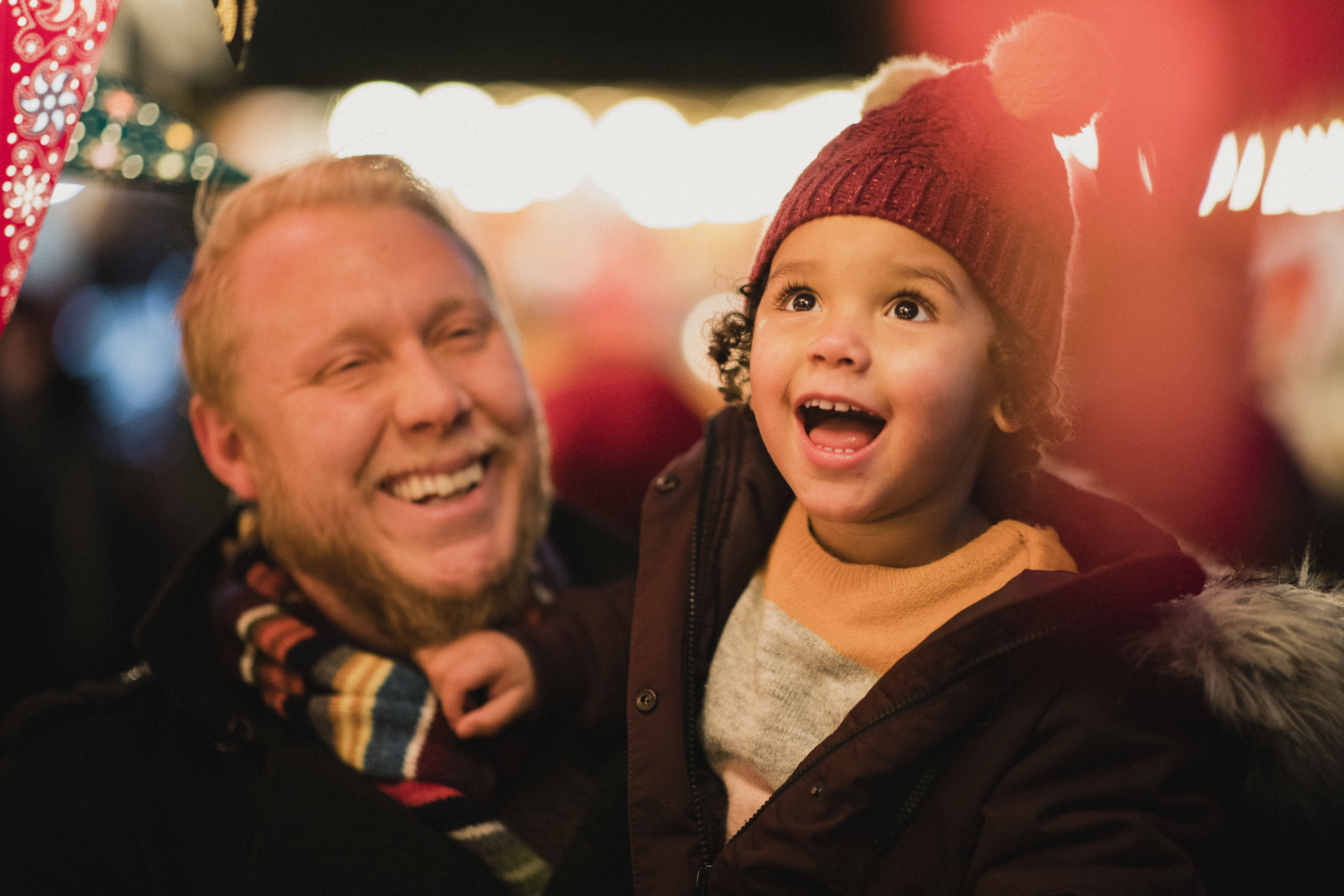 Ein Vater mit einem faszinierten Kind auf dem Weihnachtsmarkt.