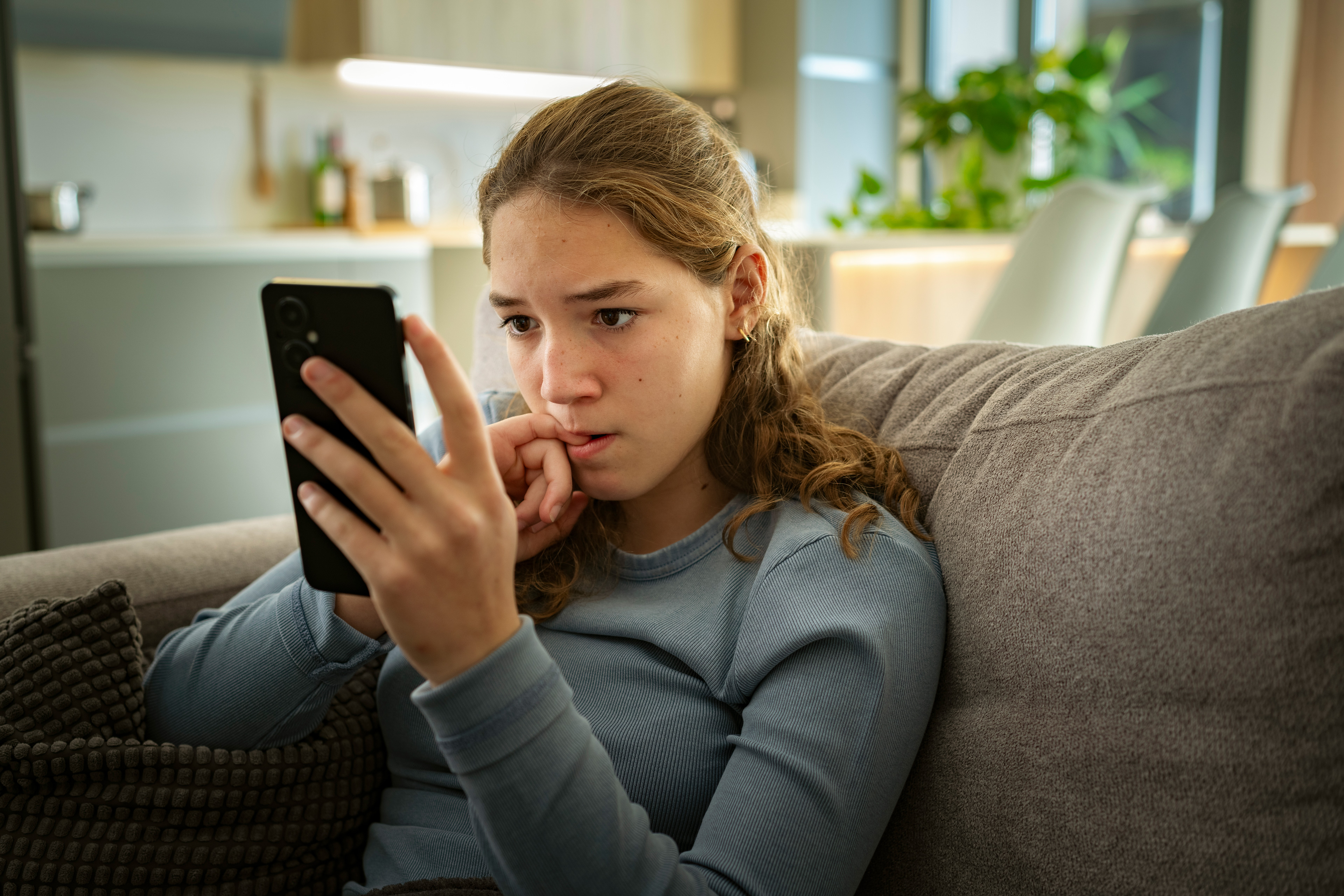 Eine Jugendliche sieht sich etwas auf dem Handy an.