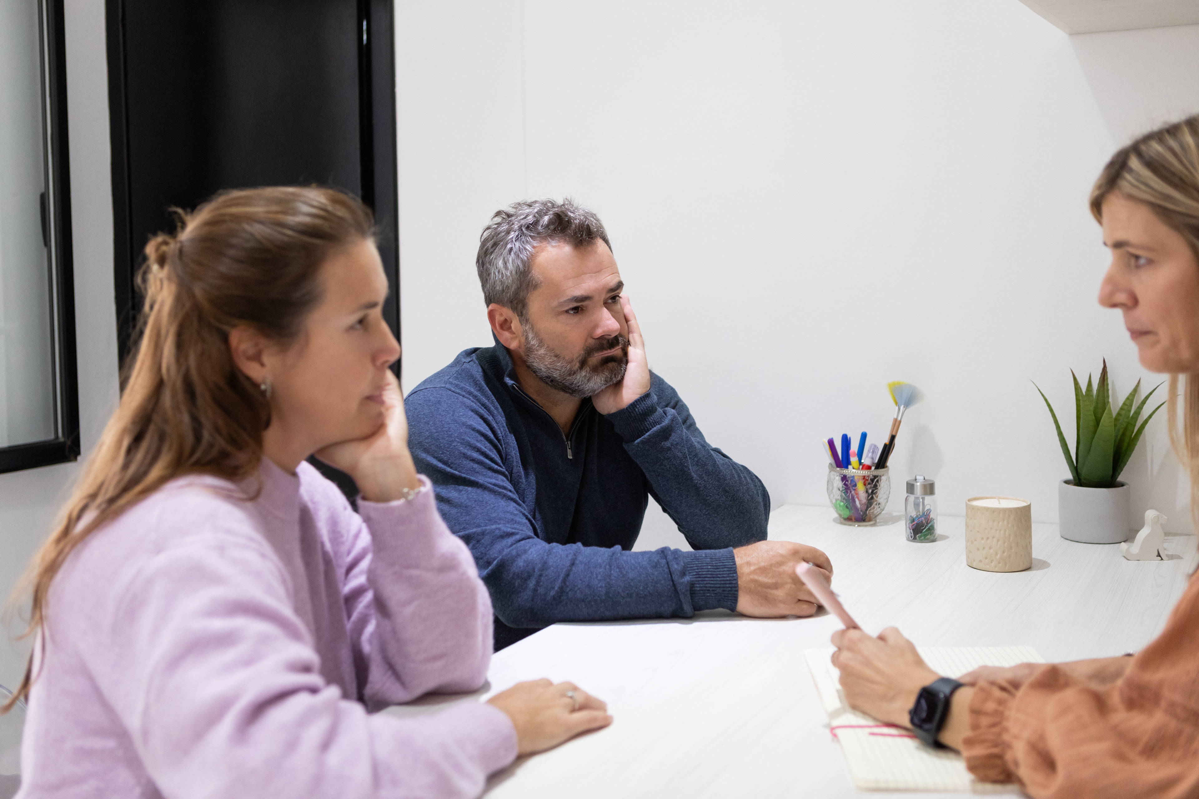 Zwei bedrückt aussehende Eltern in einem Beratungsgespräch.