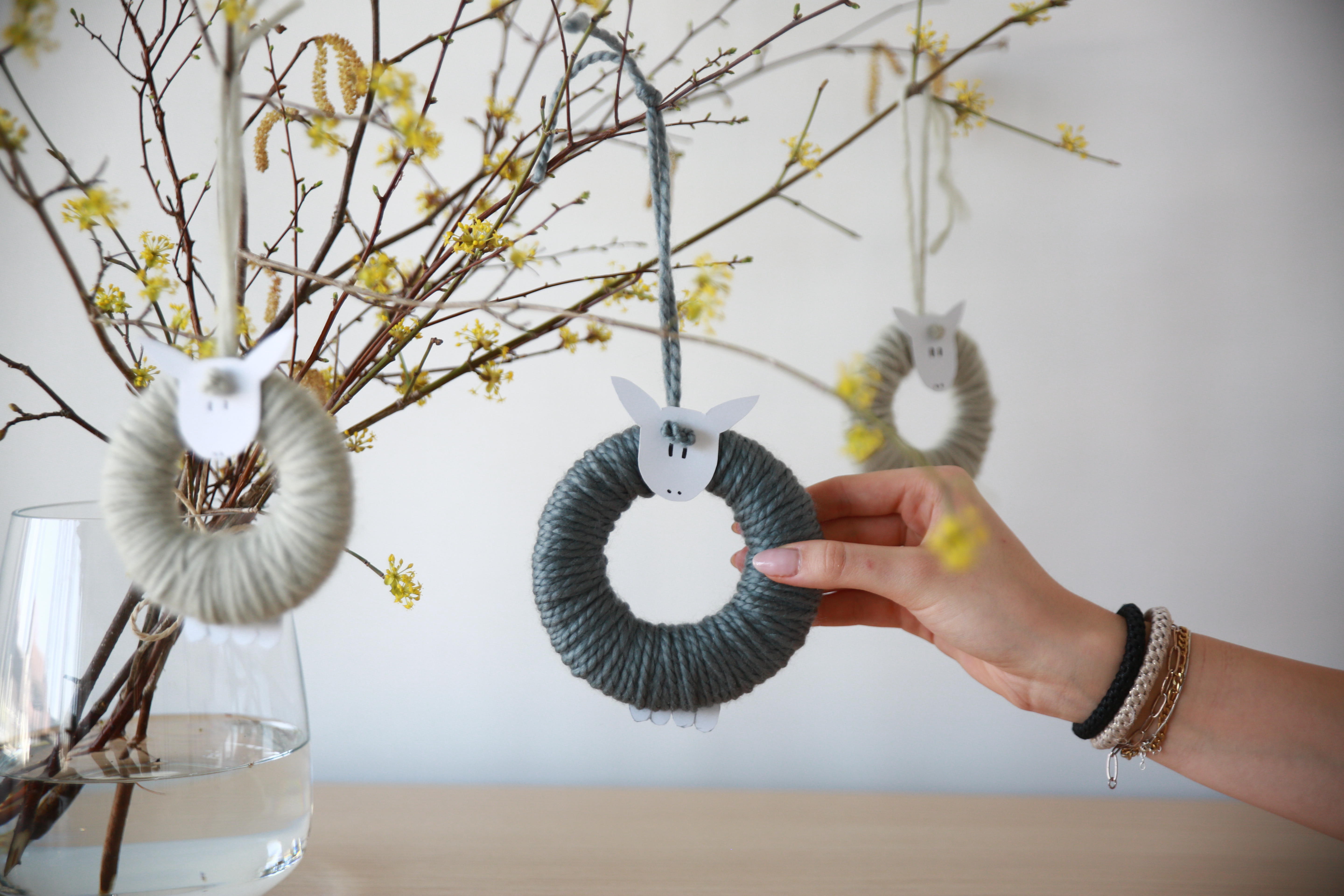 Kreativzeit: Die fertigen Schäfchen hängen an blühenden Osterzweigen.