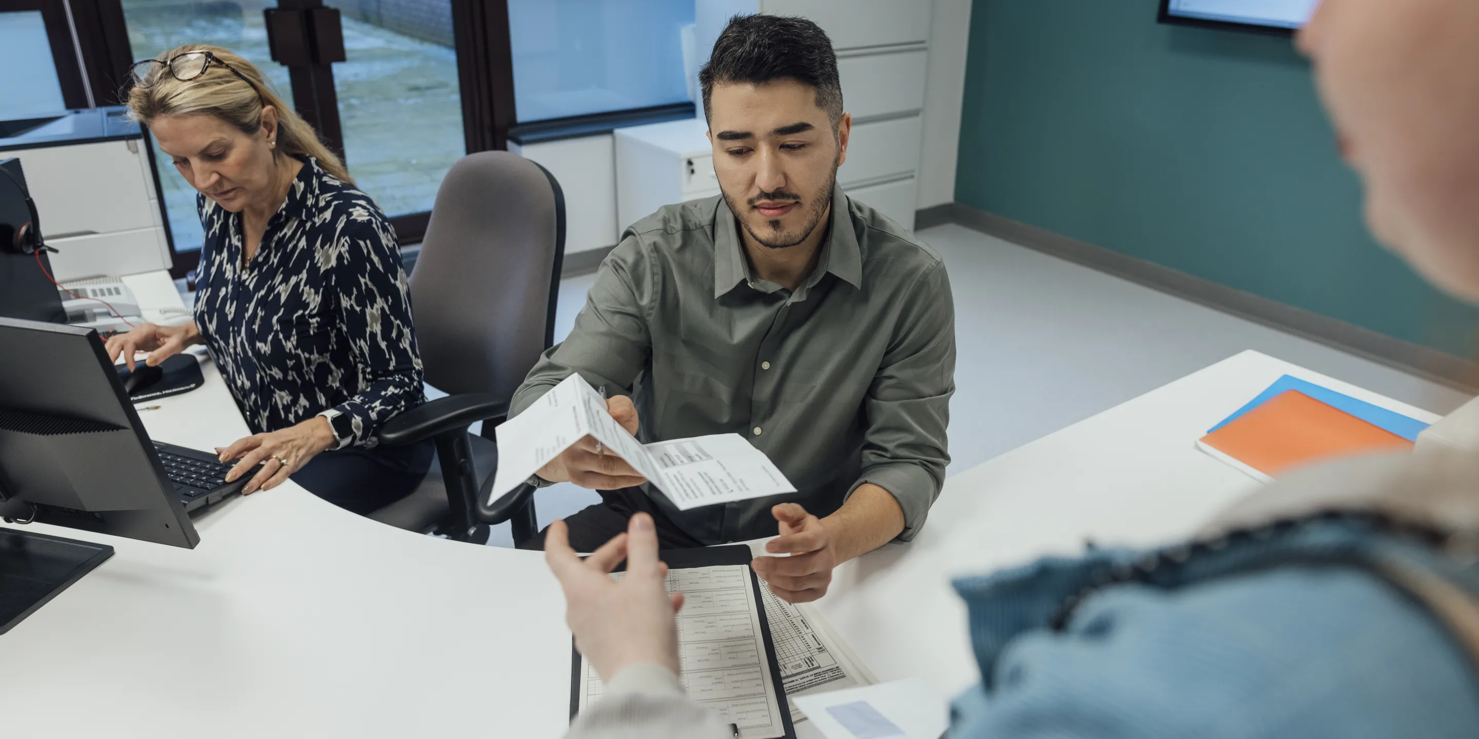 Eine Frau reicht in einer Behörde einen Antrag ein.