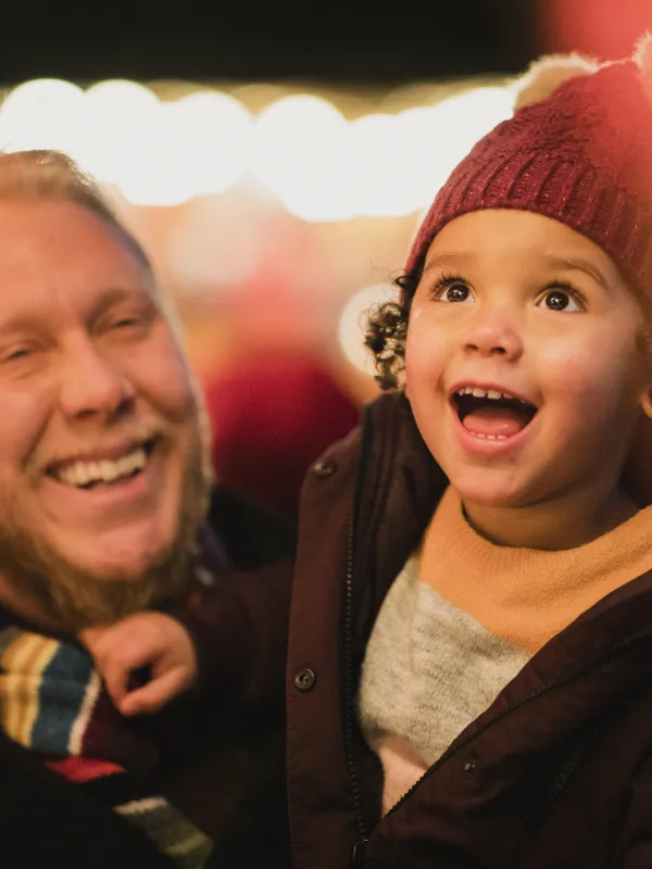 Ein Vater mit einem faszinierten Kind auf dem Weihnachtsmarkt.