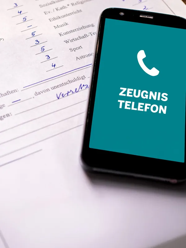 Ein Zeugnis und ein Smartphone, dass das Zeugnistelefon anruft.