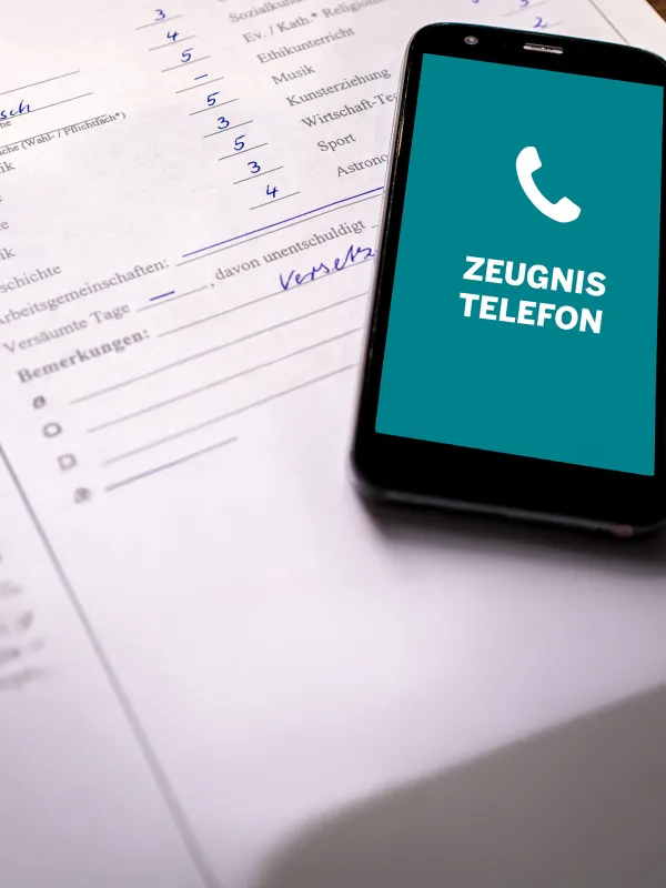 Ein Zeugnis und ein Smartphone, dass das Zeugnistelefon anruft.
