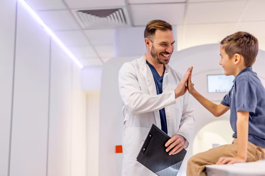 Ein Arzt gibt einem Jungen ein High-Five.
